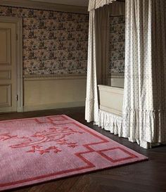 a pink area rug in the middle of a room with curtains on either side of it