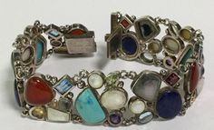 If you love jewelry with gemstones, this is definitely the bracelet for you! This amazing vintage bracelet is about 7 3/4 inches long and a bit over 3/4-inch wide.  It features an incredible rainbow of semi-precious gemstones, all set in sterling silver.  The piece weighs in at an impressive 46.3 grams!   It includes a huge variety of different stones, including turquoise, blue topaz, amethyst, citrine, lapis, carnelian, garnet, labradorite and moonstone. I've seen a lot of vintage jewelry but t Vintage Multicolor Multi-stone Jewelry, Antique Multi-stone Bracelet As Gift, Antique Multi-stone Bracelets As Gift, Multicolor Cabochon Costume Jewelry, Vintage Multi-stone Multicolor Jewelry, Vintage Multi-stone Bracelets Gift, Antique Multicolor Multi-stone Jewelry, Multi-stone Costume Jewelry Bracelet, Vintage Multicolor Stone Bracelets