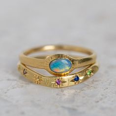 Our Hidden Treasure collection is full of perfectly imperfect pieces cast in raw gold and silver with hidden sapphires and diamonds half exposed. Each piece is a one of a kind. The Carnivale Celestial Hidden Treasure Band is set with shades of sapphires, emerald and ruby. Band width 2.6mm-2.8mm. Weight 4g approx. Pictured with a matte finish. For a high shine finish please leave a note at checkout. Opal Ring Stack, Celestial Multi-stone Yellow Gold Jewelry, Celestial Yellow Gold Multi-stone Jewelry, Celestial Multi-stone Gold Jewelry, Gold Sterling Silver Sapphire Birthstone Ring, Gold Sapphire Ring With Recycled Material, Gold Sapphire Ring With Birthstone In Sterling Silver, Gold Sapphire Rings Hand Forged, Gold Sapphire Ring With Recycled Gold