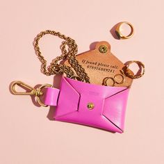 a pink leather purse with keychain and ring