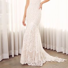 a woman in a white wedding dress is posing for the camera with her hand on her hip