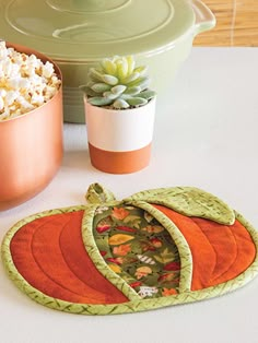 an oven mitt sitting on top of a table next to a potted plant