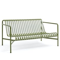 a green metal bench sitting on top of a white floor