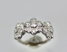 a diamond ring is shown on a white surface with the center stone surrounded by smaller diamonds