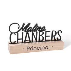 a black metal sign that says, maine chamberers principals on top of a wooden block