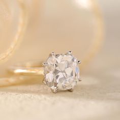 a diamond ring sitting on top of a table next to a piece of cloth and some other items