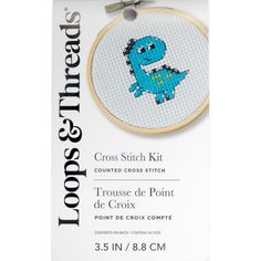 the cross stitch kit has a small blue dinosaur on it's back and is packaged in