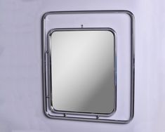 a mirror mounted to the side of a wall with a metal frame around it's edge