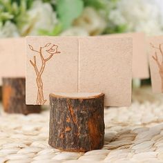 three place cards are placed next to each other on a table with flowers in the background