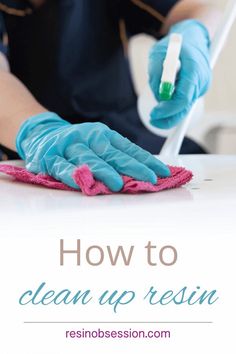 a person in blue gloves and rubber gloves cleaning a table with a pink mop