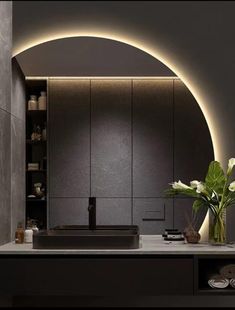 a modern bathroom with an oval light above the sink and vase on the countertop