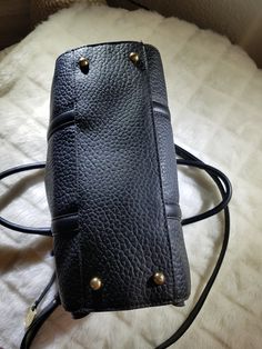 "Featuring this vintage Authentic Black Leather London Fog Handbag with long shoulder strap and Gold Tone metal hardware. The liner is in a Beige with Black lines going sideways design. There are 4 pockets in the interior while just 1 is outside on the front side. The purse does have 2 top handles and a Black zipper to protect your valuables. There is a metal hang tag with the hallmark that reads \"EST 1923 London Fog Authentic\". The purse is in excellent condition and will arrive carefully pac Black Satchel With Brass Hardware For Everyday, Top Handle Pebbled Leather Shoulder Bag With Branded Hardware, Vintage Black Shoulder Bag With Metal Hardware, Business Satchel With Brass Hardware And Double Handle, Business Shoulder Bag With Pebbled Leather And Branded Hardware, Business Shoulder Bag With Branded Hardware In Pebbled Leather, Business Shoulder Bag With Branded Hardware And Pebbled Leather, Classic Black Satchel With Metal Hardware, Vintage Satchel Tote With Branded Hardware