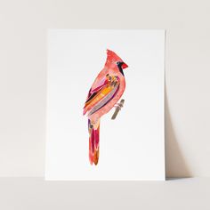 a red bird sitting on top of a white card