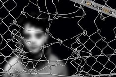 a man behind a fence with barbed wire