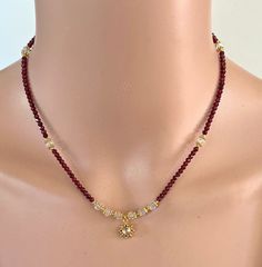 "A bewitching necklace of faceted 2mm round Red Garnets with a hand-crafted Vermeil stylized Sun charm which is set with a round Rainbow Moonstone cabochon. The charm is surrounded by 5 mm faceted Rainbow Moonstone rondelles that are accented with gold-filled beads and daisy spacers. This necklace is 15.25\" in length and has a 2\" gold-filled extender chain so you can wear it as a choker or a longer necklace. Gold-filled beads and findings. NM Jewelry Design offers one-of-a-kind and limited edition jewelry. My creations are inspired by the cultures that traded along the ancient Silk Road. I am a Certified Gemologist and Accredited Jewelry Professional.   Please contact me for more information about the other necklaces shown in this listing." Moonstone Jewelry Necklace, Garnet Beaded Necklace, Red Garnet Gemstone Beaded Necklaces, Red Multi-strand Gemstone Beaded Necklaces, Briolette Necklace, Artisan Red Multi-strand Necklace, Red Multi-strand Polished Beads Necklace, Beaded Jewelry Necklaces, Carnelian Necklace