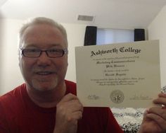 a man holding up a certificate in front of his face