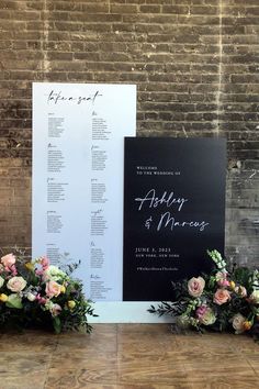 the wedding seating chart is set up next to some flowers and greenery in front of a brick wall