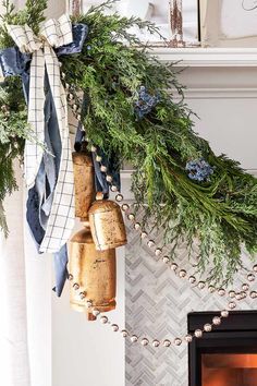 a christmas wreath with bells hanging from it's side next to a fire place