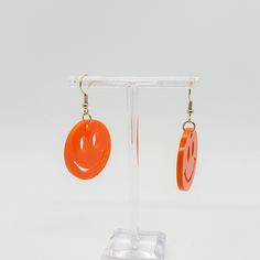 This cute pair of earrings is perfect for the 90 fan. The adorable orange smiley face charms show off your fun y2k style. They feature bright orange smiley face designs Hard acrylic provides ‌protection‌ ‌and‌ ‌durability Nickle free and hypoallergenic hooks Playful Orange Dangle Jewelry, Trendy Orange Dangle Earrings, Fun Orange Earrings As A Gift, Nickel Free Orange Earrings For Everyday, Fun Orange Earrings For Gifts, Fun Orange Earrings For Gift, Nickel-free Orange Earrings For Everyday Wear, Fun Orange Earrings For A Gift, Fun Orange Drop Earrings