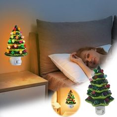 a woman sleeping in bed next to a christmas tree night light on the side table