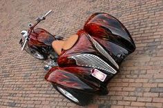 a red motorcycle parked on the side of a brick road