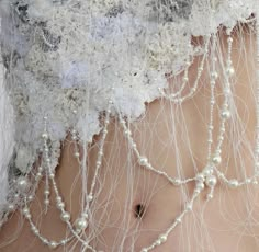 a close up of a woman's stomach with pearls and lace around her waist