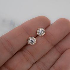 These cubic zirconia stud earrings featuring a pavé halo sparkle so bright! They are so elegant and work great for everyday first-hole studs or as wedding or bridesmaid earrings. Absolutely beautiful! We also use the highest grade of cz for an authentic diamond look! They look like real diamonds 🤩 - - -  D E T A I L S - - -  * Made of 925 Sterling Silver * We use a THICK plating of 14k Gold or Rhodium * Nickel-free & Hypoallergenic (safe for sensitive ears!) * Sold as a pair  * 7mm Diameter * Push-back closure Earrings on Model ----> 3.4mm Bezel Studs https://www.etsy.com/listing/1449220204/bezel-earring-studs-hypoallergenic?click_key=1f1bc59b800bfa52646c56483dfa9668bdf9c6c0%3A1449220204&click_sum=928f637d&ga_search_query=bezel%2Bstuds&ref=shop_items_search_7&pro=1&frs=1&sts=1 Comes in a Wedding Halo Earrings In Cubic Zirconia, Round Cubic Zirconia Flower Earrings In Fine Jewelry Style, Wedding Halo Design Cubic Zirconia Earrings, Cubic Zirconia Cluster Earrings With Halo Design For Anniversary, Cubic Zirconia Halo Earrings For Wedding, Yellow Gold Earrings With Halo Setting For Wedding, Round Cubic Zirconia Flower Earrings, Yellow Gold Halo Setting Earrings For Wedding, Yellow Gold Halo Earrings For Wedding