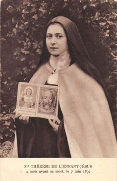 an old black and white photo of a woman holding a framed portrait in her hands