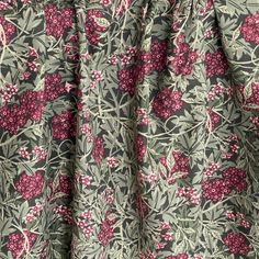 a close up view of the fabric with flowers and leaves on it, as well as pink