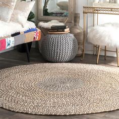 a round rug in the middle of a living room with a mirror and chair behind it