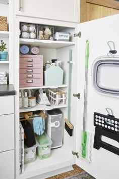 the inside of a white cabinet filled with cleaning supplies