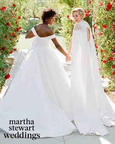 two women in wedding dresses holding hands