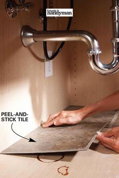 a person working on a tile under a sink