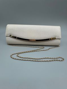 Kate Landry Ivory and gold Evening Bag.  This gorgeous bag is in like new condition - only minor scratches on the gold accent bar.  The ivory is patterned and give off a wonderful shimmer to add to its elegance.  This bag would be a wonderful go to bag for your formal event or wedding!  This bag has classic style and is larger than most formal clutches - so you can keep you makeup, key and purse all in one place - with room to spare.  Ivory satin interior The heavy gold braided chain fully hides inside the bag when you want to use it as a clutch - or allows for a 25" hang.  Bag measure 12" by 4" by 1.5".   Get it - you won't be disappointed!  Free Shipping White Evening Bag With Gold-tone Hardware, Gold Shoulder Bag Clutch For Formal Occasions, Elegant Beige Bags For Events, White Party Bags With Gold-tone Hardware, Cream Evening Bag With Detachable Strap For Formal Events, Cream Evening Bag With Detachable Strap For Formal Occasions, Classic Beige Evening Bag, Cream Evening Shoulder Bag For Parties, Elegant White Evening Bag With Detachable Strap