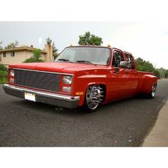 an old red truck is parked on the street