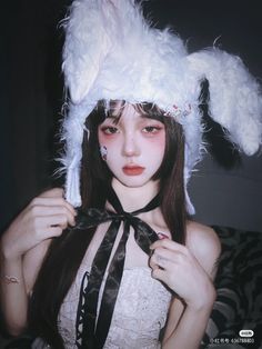 a woman with long hair wearing a white bunny ears hat and black ribbon around her neck