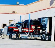 a large semi truck parked in front of a building next to another semi - truck