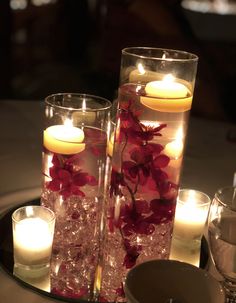 candles and flowers in glass vases on a table