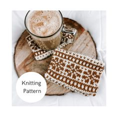 two knitted coasters sitting on top of a wooden plate next to a cup of coffee