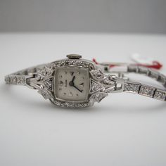 "For sale: (1) g123 14k White Gold Women's Diamond Elgin Watch PLEASE READ ENTIRE DESCRIPTION BEFORE PURCHASING Pre-owned item. Good condition. Please see pictures for details. Sold as is, as seen on pictures. This beautiful ladies Elgin Art Deco watch contains 62 diamonds, all of which are round cut. It is stamped. Specifics: 14k White gold Diamonds: .86TCW Mechanical Length: 5.5 inches Case size with crown: 15.9 mm Lug width: 4mm Please be 100% sure of your purchase before buying, as we do not Wedding Jewelry And Watches With 17 Jewels Round Dial, Vintage White Gold Jewelry For Formal Occasions, Luxury Anniversary Watch, Vintage Diamond White Jewelry And Watches For Anniversary, Timeless Diamond Jewelry And Watches For Gifts, Vintage Diamond Watch With Round Dial For Formal Occasions, Timeless Yellow Gold Diamond Watch For Wedding, Formal Diamond Watch With 17 Jewels And Round Dial, White Gold Wedding Watches With Diamond Hour Markers