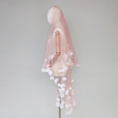 a mannequin wearing a pink veil with white flowers