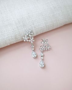 Delicate pear shape dangle earring seamlessly blend with floral rhinestones and accented with small pearls adds a classic touch for your ensemble. Pair them with an elegant dress for formal affair, or let them elevate your casual style. Perfect for date night, wedding, bridesmaids, holiday party, and any special occasions. DETAILS: LENGTH: 1.75"COLOR: SILVERIMPORTED MATERIALS Formal Pearl Embellished Drop Chandelier Earrings, Formal Pearl Embellished Chandelier Drop Earrings, Classic Flower Shaped Earrings For Wedding, Formal Dangle Flower Earrings With Cubic Zirconia, Elegant Pearl Embellished Dangle Chandelier Earrings, Elegant Crystal Flower Earrings For Party, Elegant Flower Earrings With Sparkling Stones For Wedding, Elegant Wedding Flower Earrings With Sparkling Stones, Elegant Crystal Embellished Bridal Earrings For Anniversary