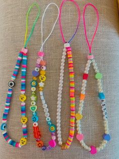 several bracelets are laid out on top of a bed with buttons and beads attached to them