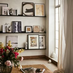 a vase filled with flowers sitting on top of a wooden table next to a window