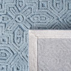 a close up view of the corner of a blue rug with an intricate design on it