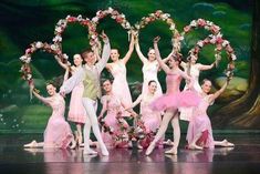 a group of people on stage with wreaths in the shape of letters and flowers