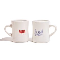 two white coffee mugs sitting next to each other on top of a white surface