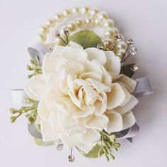 a bridal bouquet with pearls and flowers on the headbands is displayed against a white background