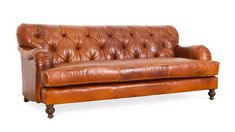 a brown leather couch sitting on top of a white floor