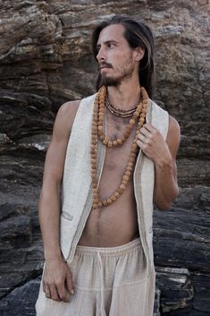 a man with long hair and no shirt wearing beads